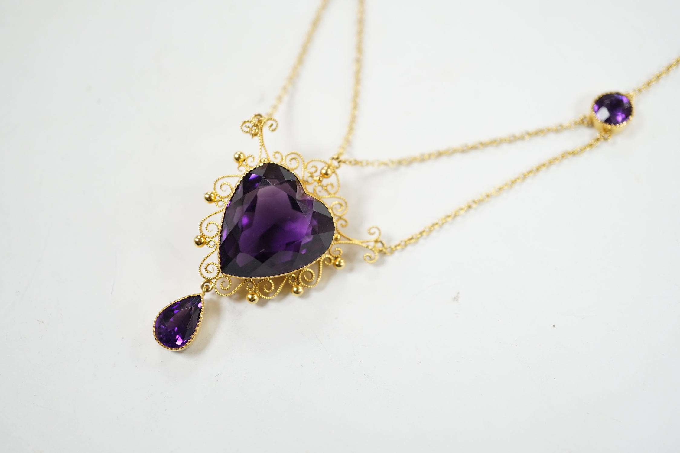 A Victorian style 9ct and four stone amethyst drop pendant necklace, the pendant set with heart shaped central stone and pear cut drop, overall 46cm, gross weight 8 grams.